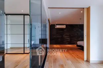Spacious modern living room with wooden flooring and glass partitions