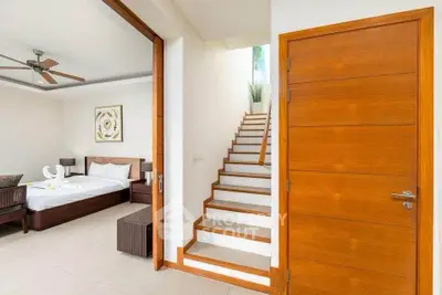 Spacious bedroom with modern decor and wooden staircase in luxury home