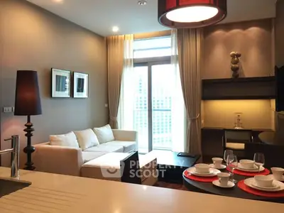 Modern living room with elegant decor and natural light, featuring a cozy sofa and stylish dining area.