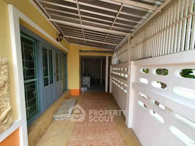 Charming covered entrance with tiled pathway and decorative wall accents.