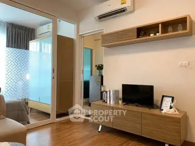 Modern living room with wooden flooring, sleek TV stand, and air conditioning unit.