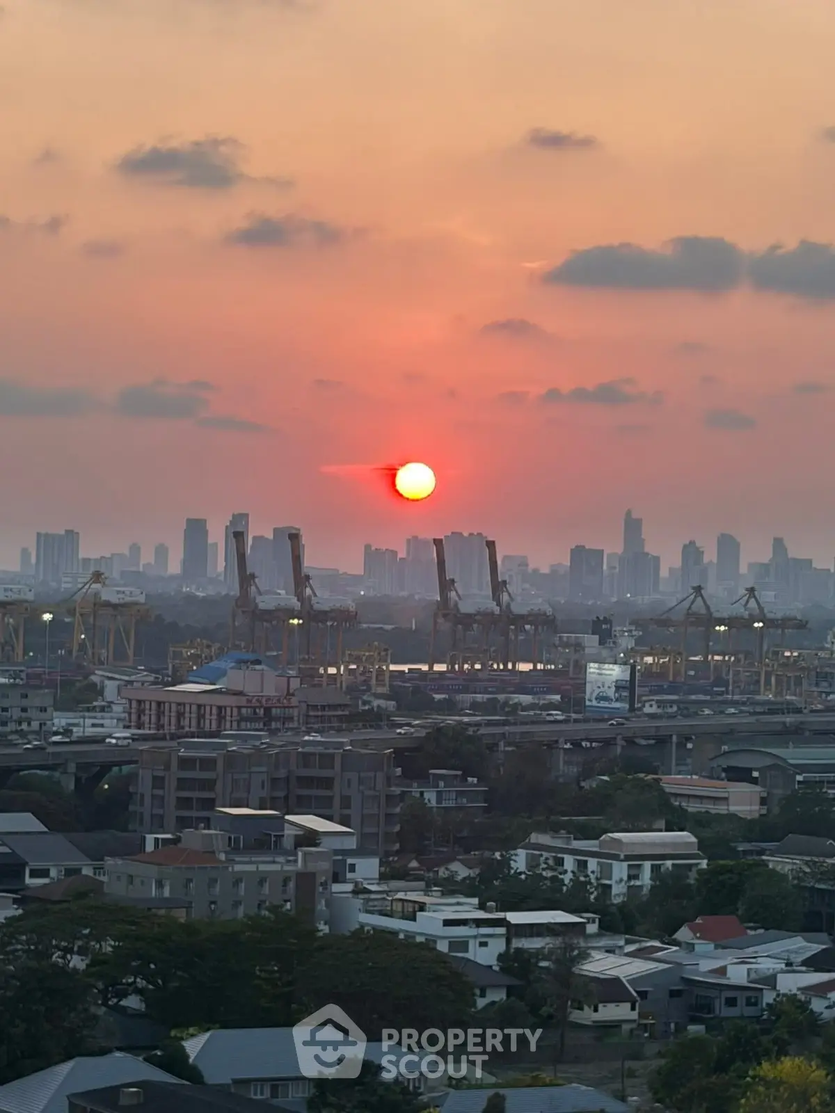 Stunning cityscape view at sunset with skyline and cranes, perfect for urban living enthusiasts.