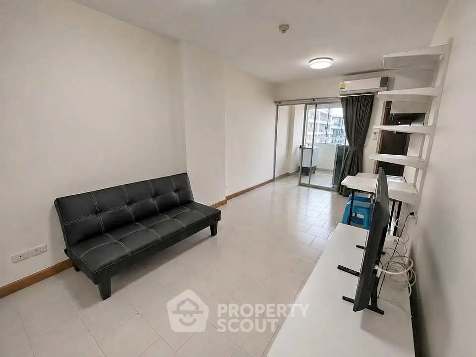 Spacious living room with modern sofa and balcony access in urban apartment