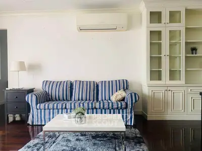 Charming living room with striped sofa and elegant cabinetry, perfect for cozy gatherings.