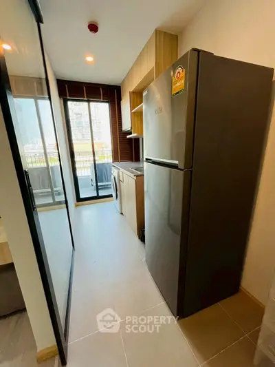 Modern kitchen with sleek appliances and balcony view in urban apartment