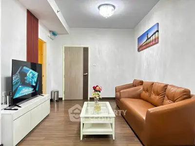 Modern living room with leather sofa and flat-screen TV, elegant decor.