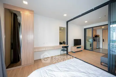 Modern open-plan apartment with spacious living area and stylish bedroom, featuring sleek wooden flooring and contemporary decor.