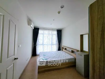 Spacious bedroom with large window and modern furnishings