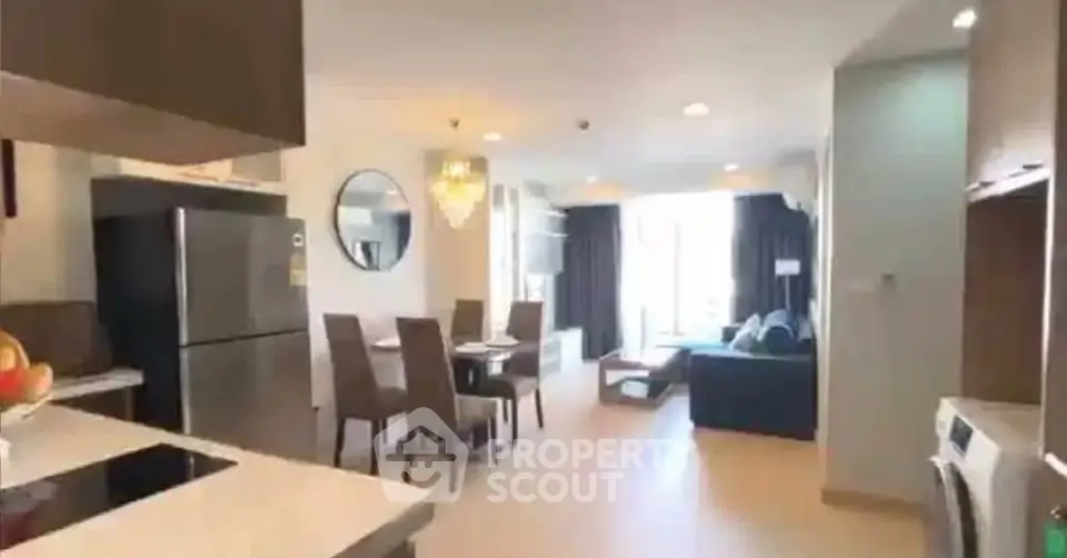 Spacious open-plan living room with modern kitchen and dining area, featuring elegant decor and ample natural light.