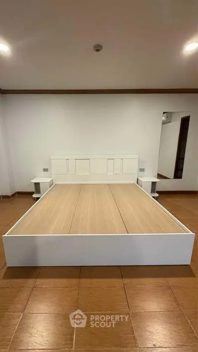 Spacious bedroom with modern bed frame and tiled flooring