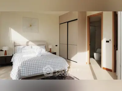 Spacious bedroom with modern decor and ensuite bathroom in a bright, elegant apartment.