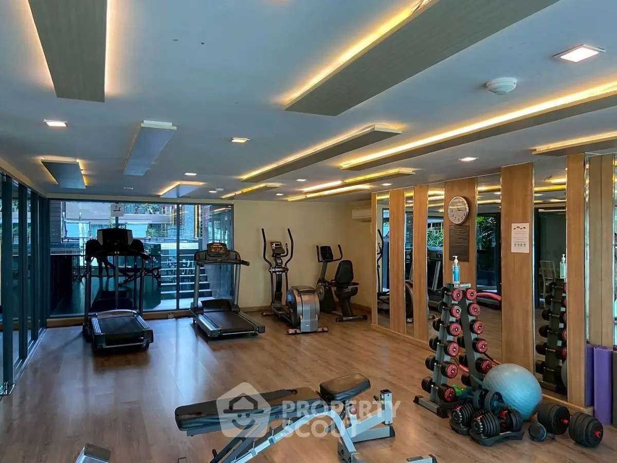 Modern gym with state-of-the-art equipment and mirrored walls in a luxury residential building.