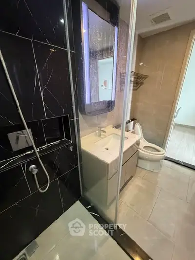 Modern bathroom with sleek black marble shower and elegant fixtures