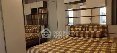 Cozy bedroom with checkered bedding and mirrored wardrobe in modern apartment.