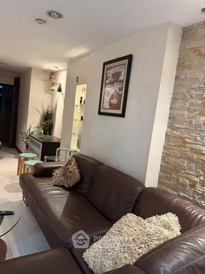 Stylish living room with leather sofa and modern decor, perfect for relaxation and entertaining.
