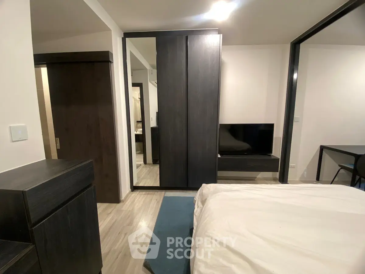 Modern bedroom with sleek furniture and mirrored wardrobe doors, offering a stylish and functional living space.