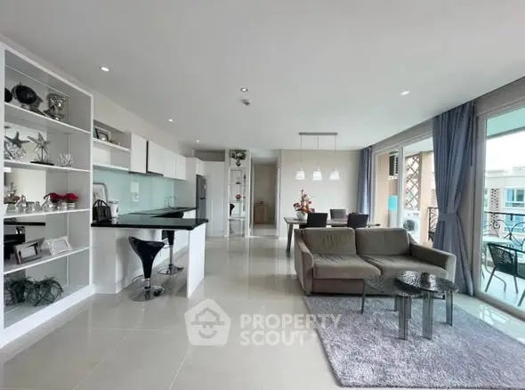 Spacious modern living room with open kitchen and balcony view