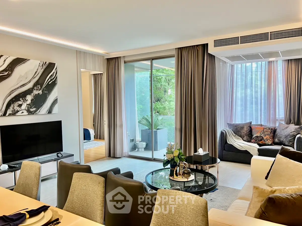 Luxurious living room with modern decor and large windows overlooking greenery.