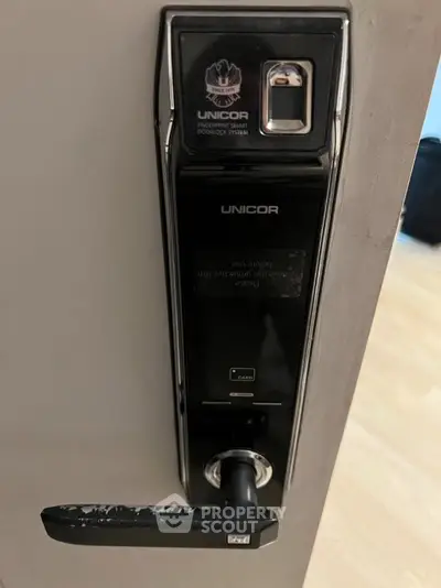 Modern digital door lock with fingerprint scanner on sleek wooden door.