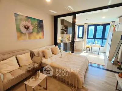 Modern studio apartment with cozy living area and city view, featuring stylish decor and natural light.
