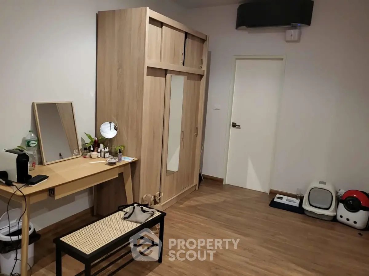 Spacious bedroom with wooden wardrobe and vanity, perfect for modern living.