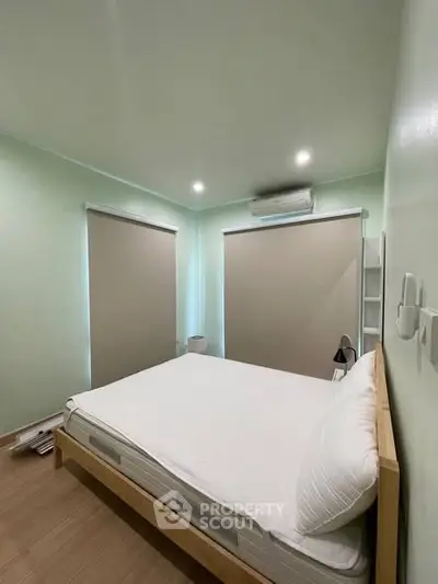 Spacious bedroom with modern design and natural light, featuring a comfortable bed and stylish decor.