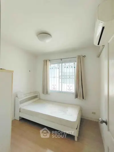 Cozy bedroom with natural light and minimalist decor, perfect for relaxation and comfort.