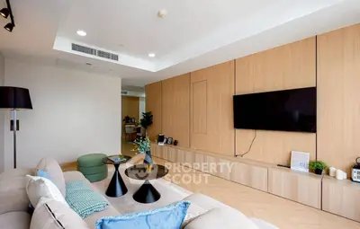Modern living room with stylish decor and wall-mounted TV in a contemporary apartment.