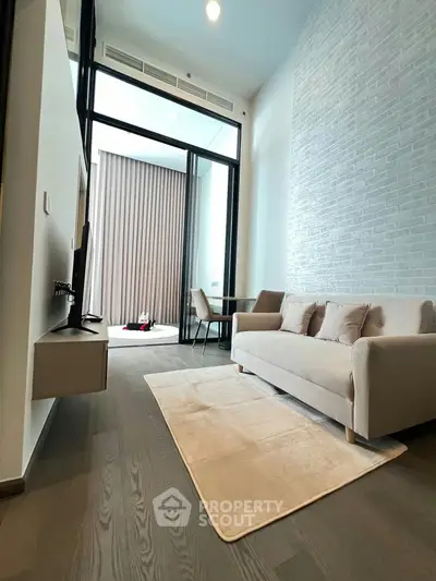 Modern living room with high ceiling and stylish decor in a contemporary apartment.