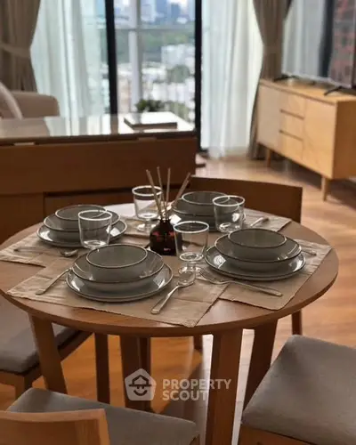 Elegant dining area with city view, featuring a stylish table setting and modern decor.