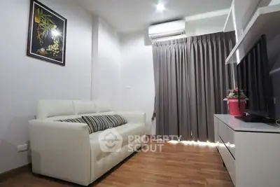 Modern living room with white sofa, wooden flooring, and air conditioning unit.