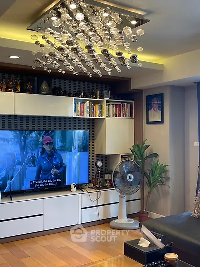 Modern living room with elegant chandelier and built-in shelving