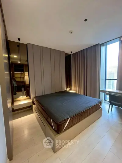 Modern bedroom with sleek design and large windows offering city views.