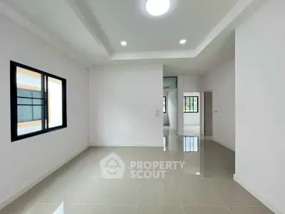 Spacious modern living room with glossy tiled floors and large windows