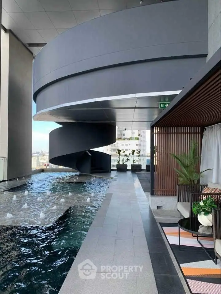 Luxurious rooftop pool with modern spiral staircase and stylish seating area.
