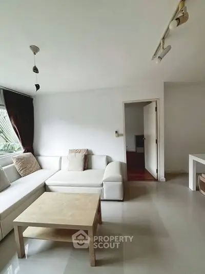 Spacious living room with modern white sofa and natural light