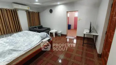 Spacious bedroom with modern amenities and stylish decor, featuring a comfortable bed and sleek TV setup.