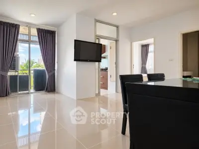 Spacious modern living room with sleek tile flooring and balcony view.