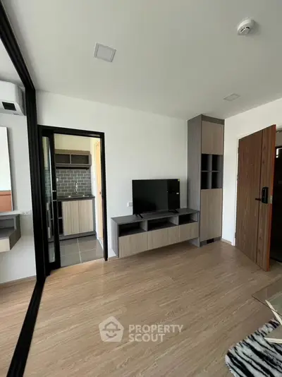 Modern living room with sleek TV unit and open kitchen view