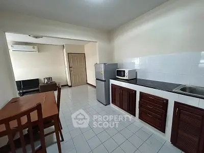 Spacious kitchen with dining area and modern appliances in a cozy apartment.