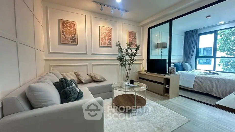Modern living room with cozy sofa and stylish decor adjacent to a bright bedroom.