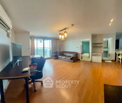 Spacious living room with modern furnishings and large windows offering natural light.