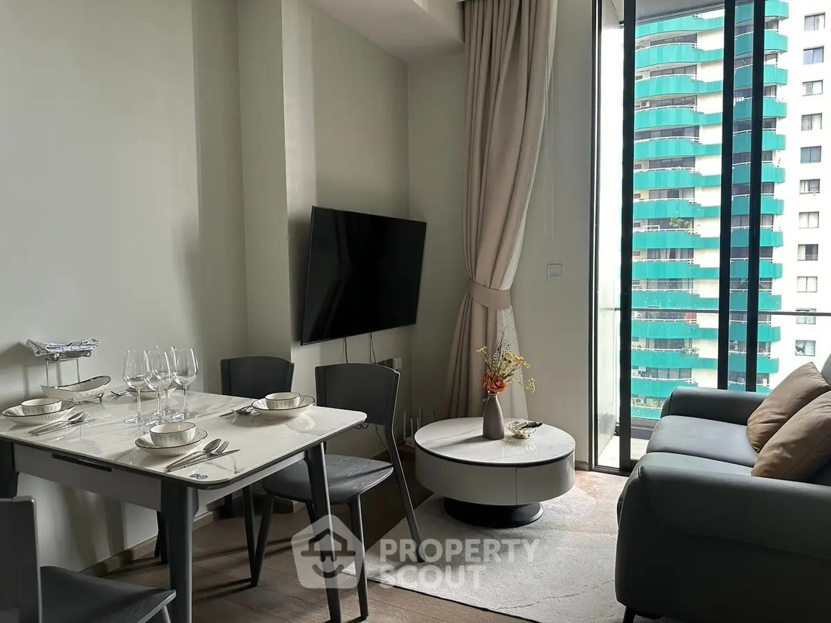 Modern living room with dining area and large windows offering city view.