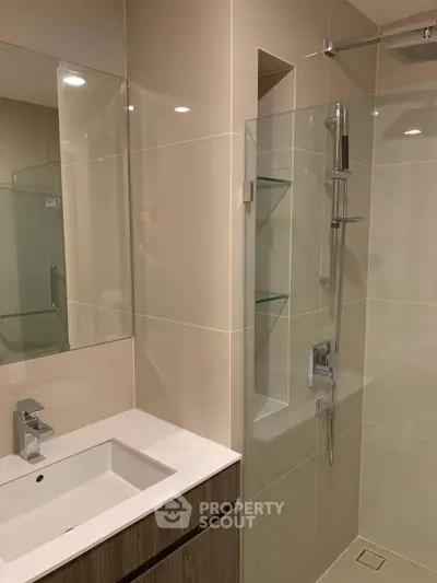 Modern bathroom with sleek shower and stylish vanity in contemporary apartment.