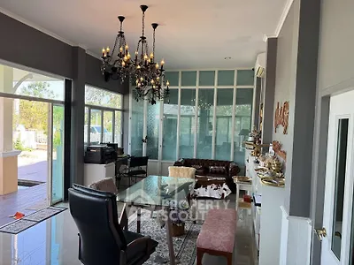 Elegant living room with chandelier and glass wall overlooking pool area