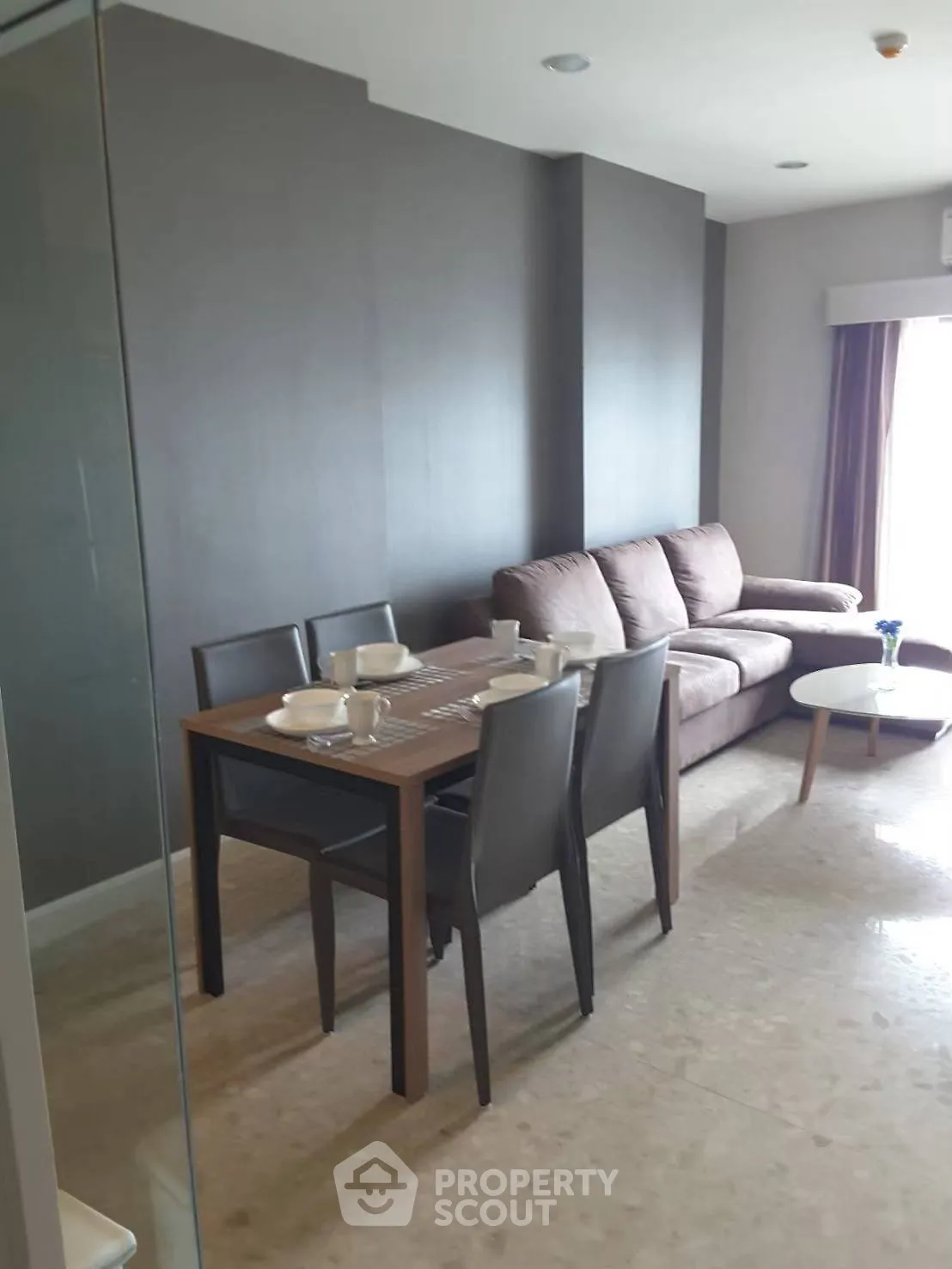 Modern living room with stylish furniture and dining area in a cozy apartment.