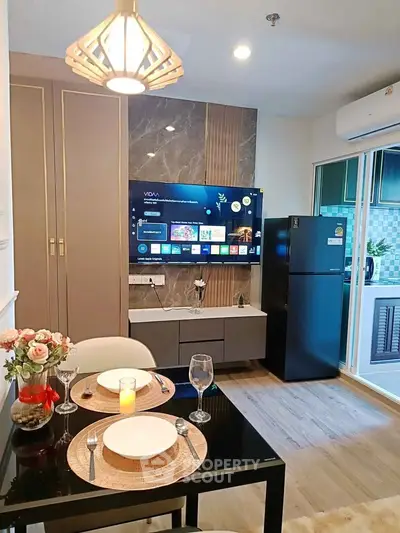 Modern living room with stylish decor, wall-mounted TV, and elegant dining setup in a cozy apartment.