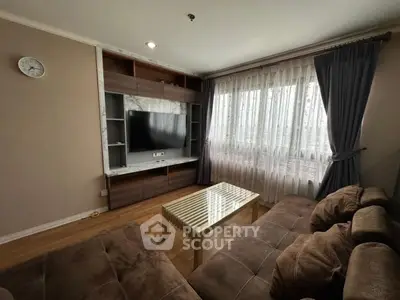 Cozy living room with modern TV setup and plush sofas, perfect for relaxation.