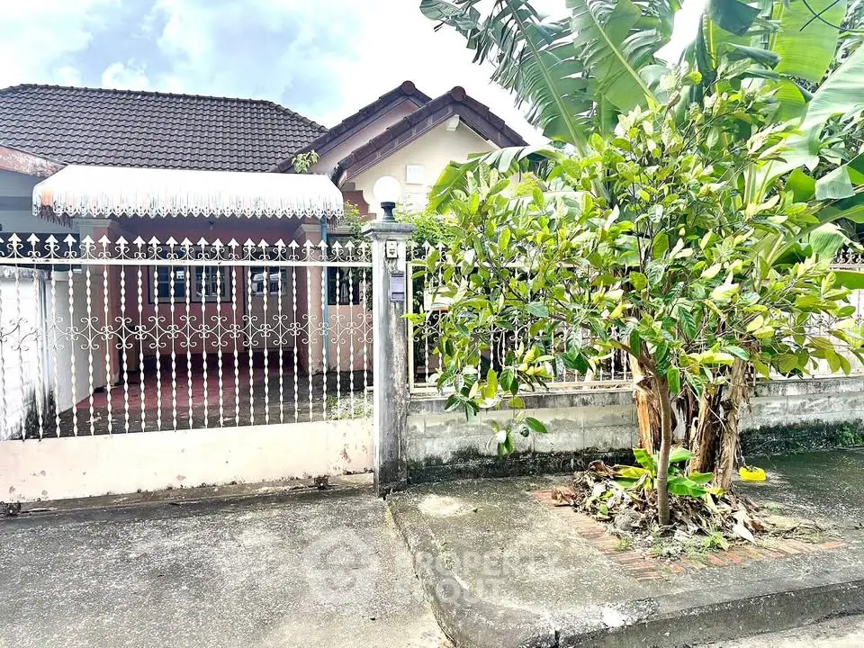 Charming suburban home with lush greenery and secure gated entrance.