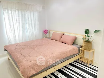 Cozy bedroom with stylish decor and natural light, featuring a comfortable bed and modern accents.